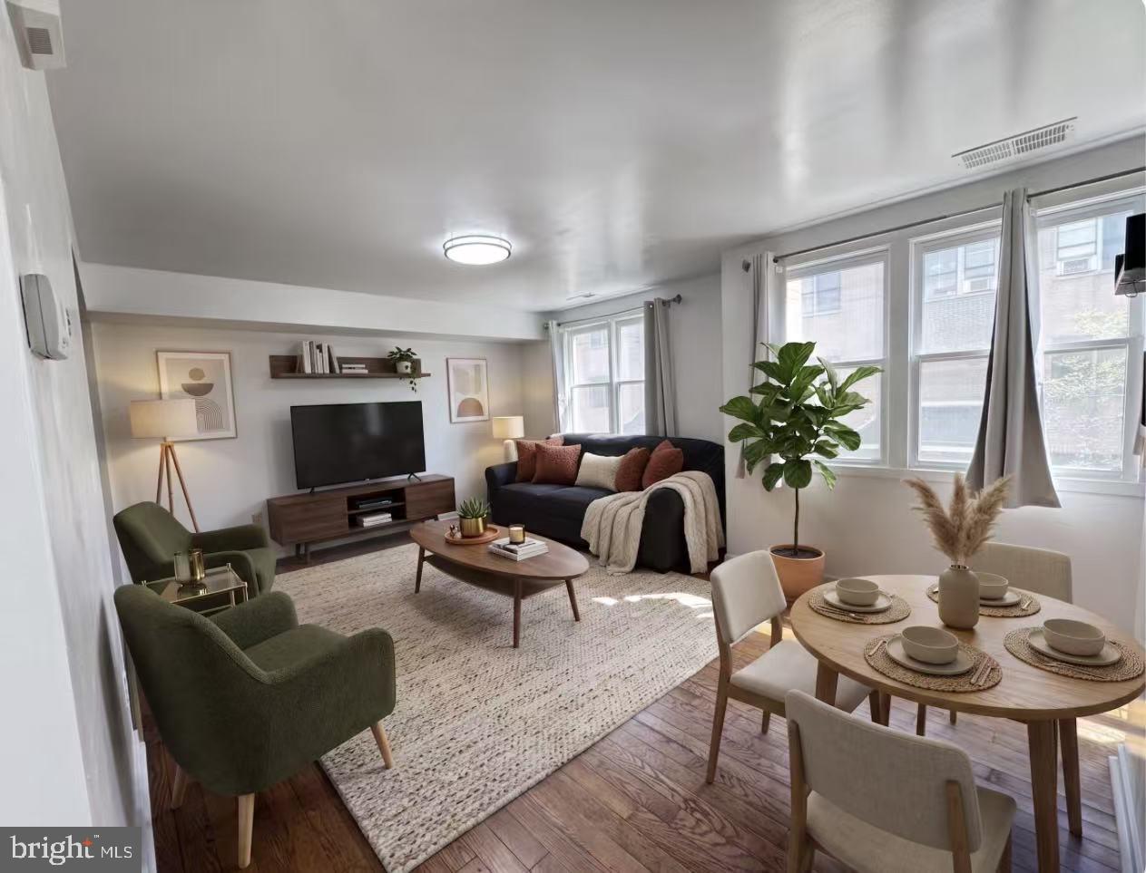 304 North 8th Street Philadelphia, PA 19123 - Photo 1 of 16 a living room with furniture a flat screen tv and a large window