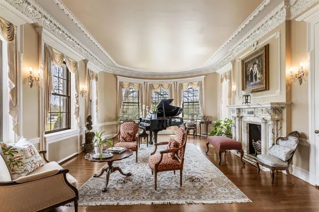 a living room with fireplace furniture and a large window
