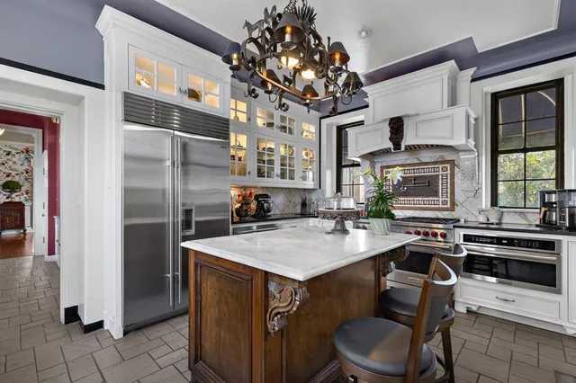 a kitchen with a table chairs refrigerator and cabinets