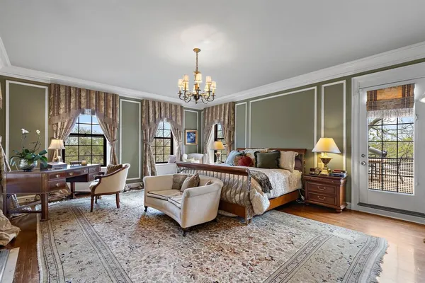 a spacious bedroom with a bed and a chandelier
