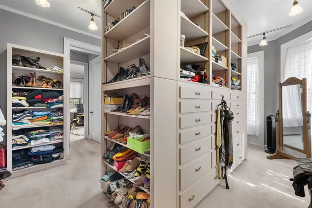 a view of walk in closet with clothes and shoes
