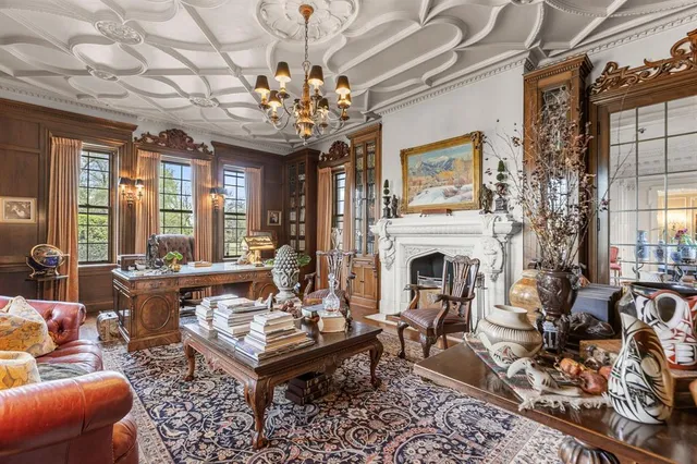 a living room with furniture a chandelier and a fireplace