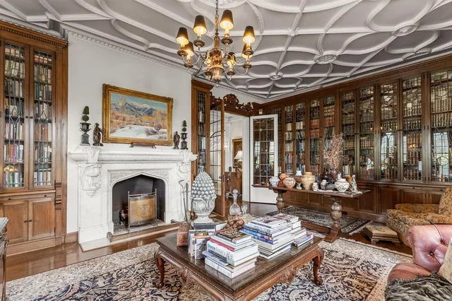 a living room with furniture a chandelier and a fireplace