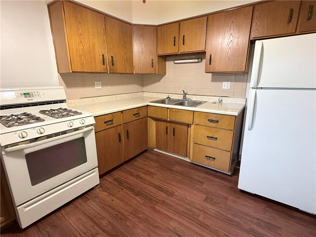 112 Greydon Avenue McKees Rocks, PA 15136 - Photo 9 of 14 a kitchen with granite countertop wooden cabinets and white appliances