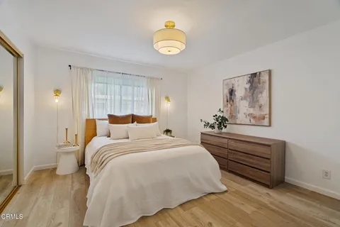 a bedroom with a bed and a potted plant