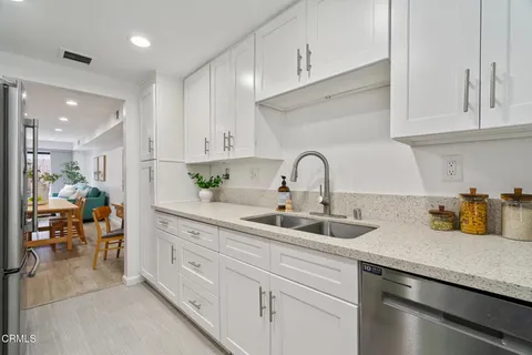 a kitchen with granite countertop a sink a stove and cabinets