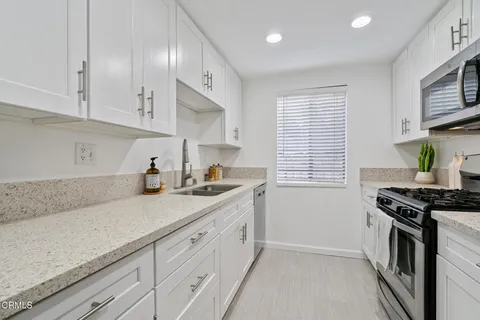 a kitchen with stainless steel appliances granite countertop a stove refrigerator and microwave