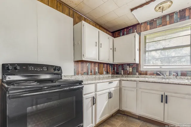 a kitchen with a sink stove and cabinets