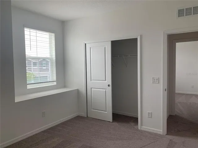 an empty room with windows and closet