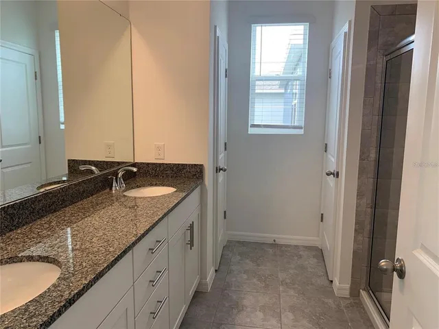 a bathroom with a granite countertop sink and a mirror