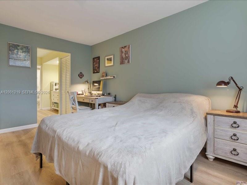 6193 Rock Island Road, Unit 105 Tamarac, FL 33319 - Photo 15 of 24 a bedroom with a bed and wooden floor