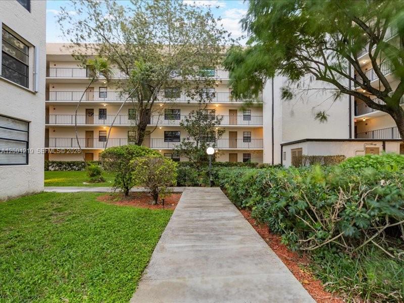6193 Rock Island Road, Unit 105 Tamarac, FL 33319 - Photo 22 of 24 a front view of a building with a garden