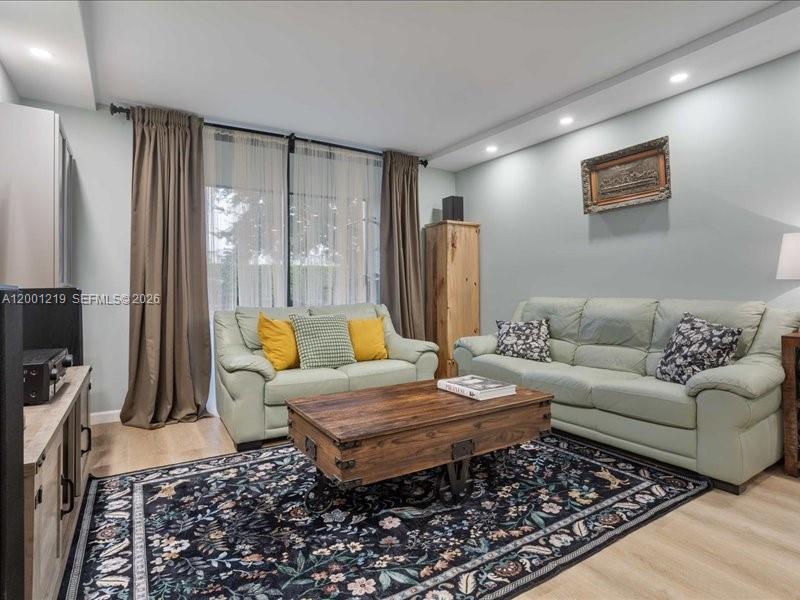 6193 Rock Island Road, Unit 105 Tamarac, FL 33319 - Photo 5 of 24 a living room with furniture and a flat screen tv
