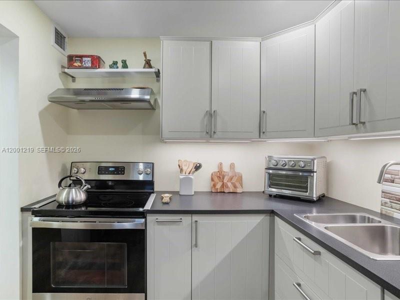 6193 Rock Island Road, Unit 105 Tamarac, FL 33319 - Photo 9 of 24 a kitchen with a stove and cabinets