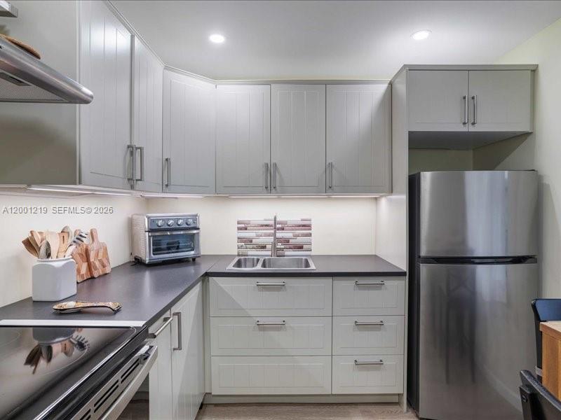 6193 Rock Island Road, Unit 105 Tamarac, FL 33319 - Photo 10 of 24 a kitchen with stainless steel appliances granite countertop a refrigerator and a stove
