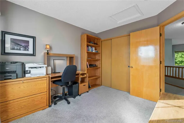 a view of a workspace with furniture and a window