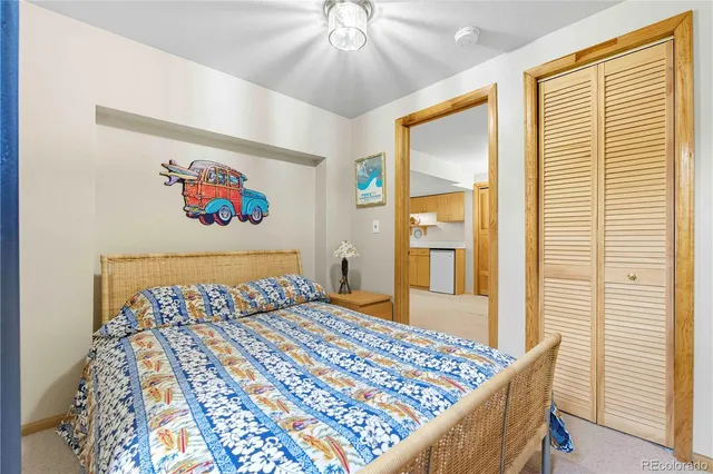 a bedroom with a bed and a painting on the wall