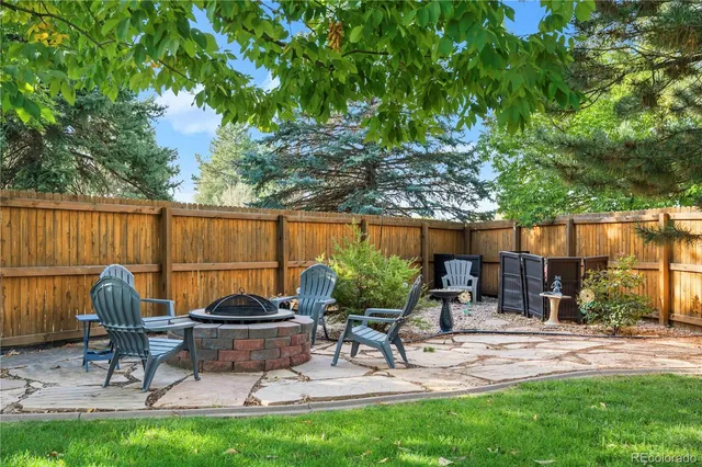 a view of a backyard with a patio table and chairs