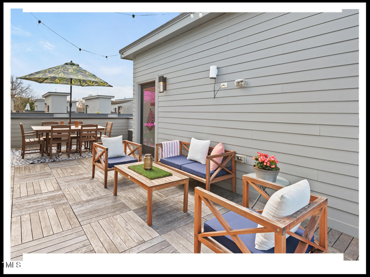 712 East Edenton Street, Unit 105 Raleigh, NC 27601 - Photo 43 of 48 a roof deck with a dining table and chairs under an umbrella