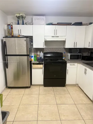 a kitchen with a refrigerator a stove a microwave and cabinets