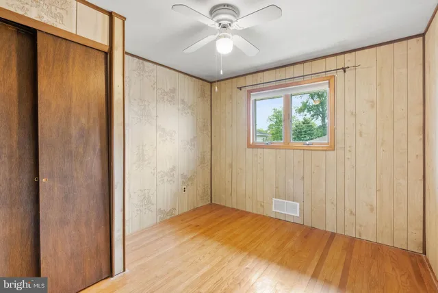 a view of a hallway with a chandelier fan and wooden floor