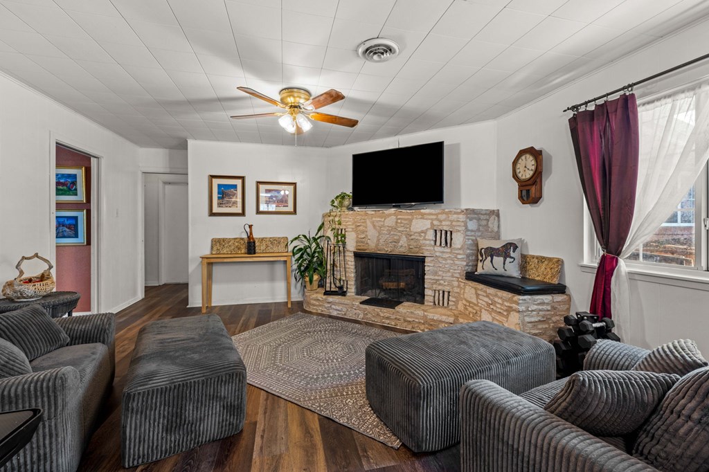 825 Golf Street Kerrville, TX 78028 - Photo 11 of 38 a living room with furniture a flat screen tv and a fireplace