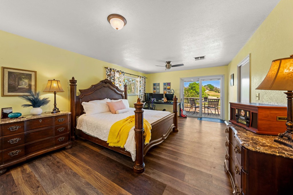 825 Golf Street Kerrville, TX 78028 - Photo 13 of 38 a spacious bedroom with a bed and wooden floor