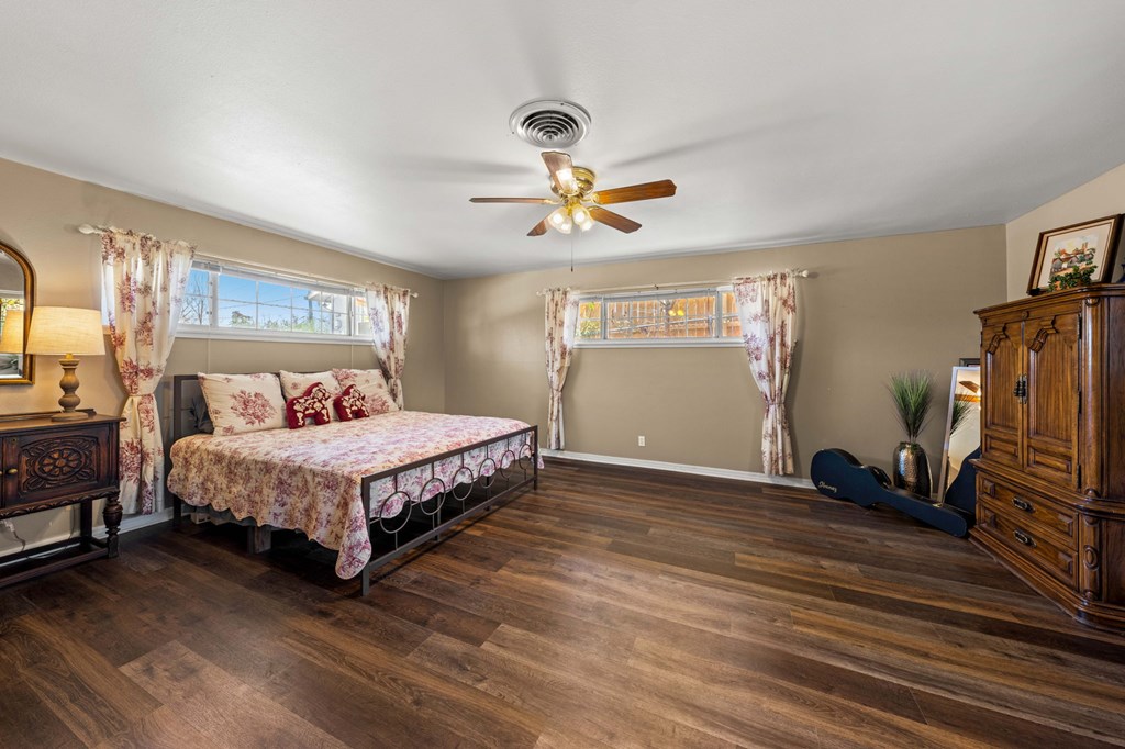 825 Golf Street Kerrville, TX 78028 - Photo 19 of 38 a bedroom with a bed and a chandelier