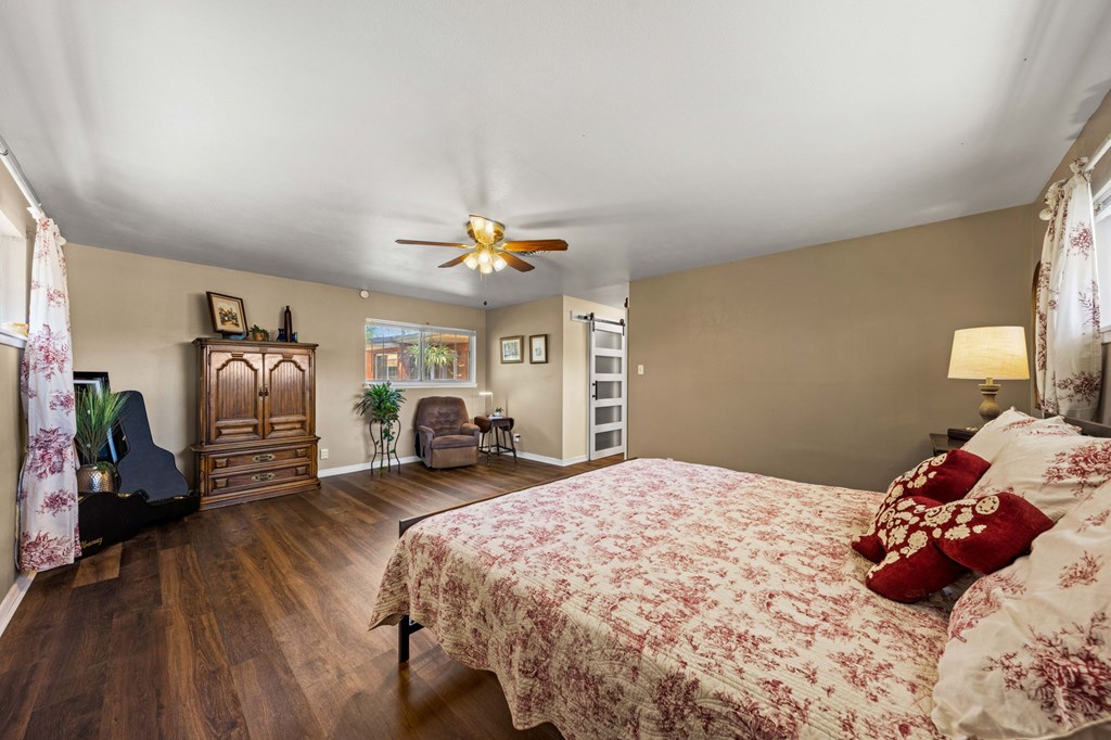 825 Golf Street Kerrville, TX 78028 - Photo 20 of 38 a bedroom with a bed and a chandelier