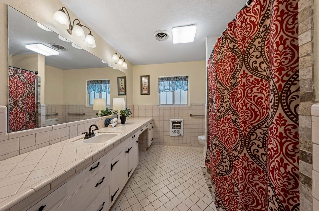 825 Golf Street Kerrville, TX 78028 - Photo 21 of 38 a spacious bathroom with a double vanity sink a mirror and a shower