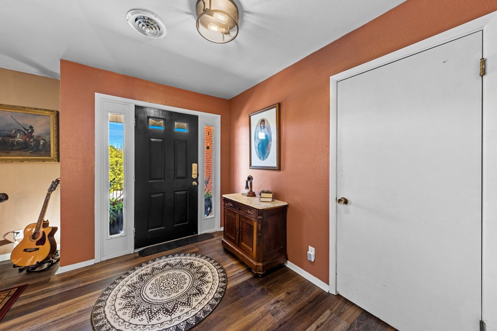 825 Golf Street Kerrville, TX 78028 - Photo 5 of 38 a view of a hallway with wooden floor and a livingroom