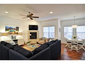 a living room with furniture a flat screen tv and a large window