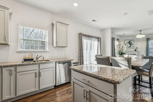 a kitchen with a refrigerator a sink and chairs