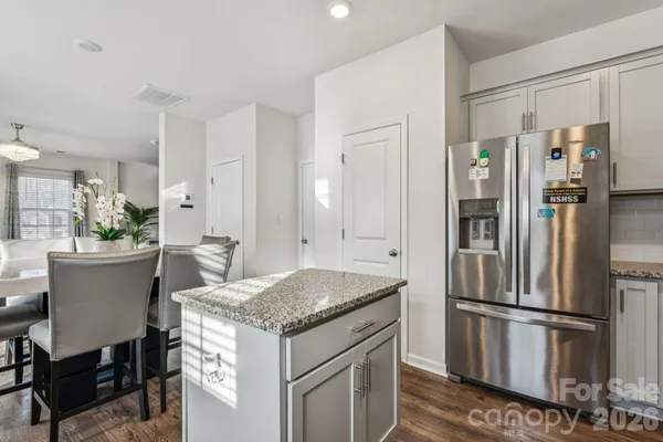 a kitchen with granite countertop white cabinets and stainless steel appliances