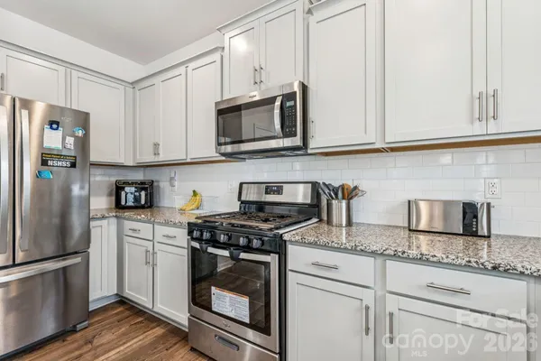 a kitchen with granite countertop a sink stove and cabinets
