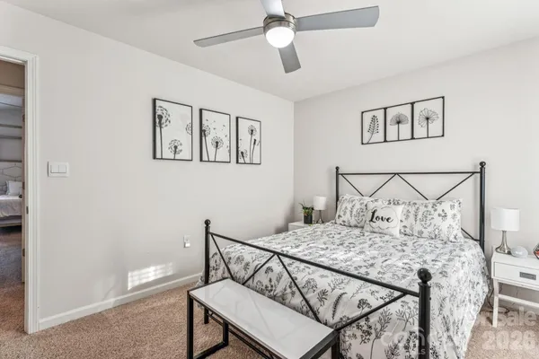 a bedroom with a bed a chandelier and a chair