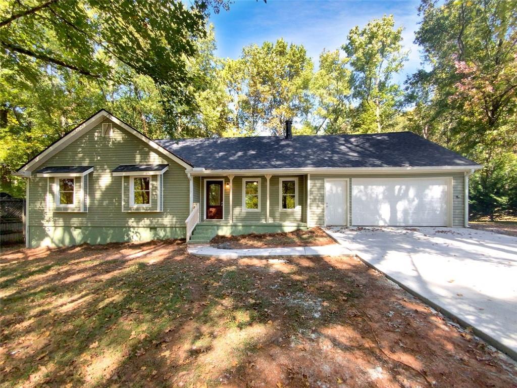 2751 Spring Street Dacula, GA 30019 - Photo 1 of 1 a front view of a house with a garden and trees