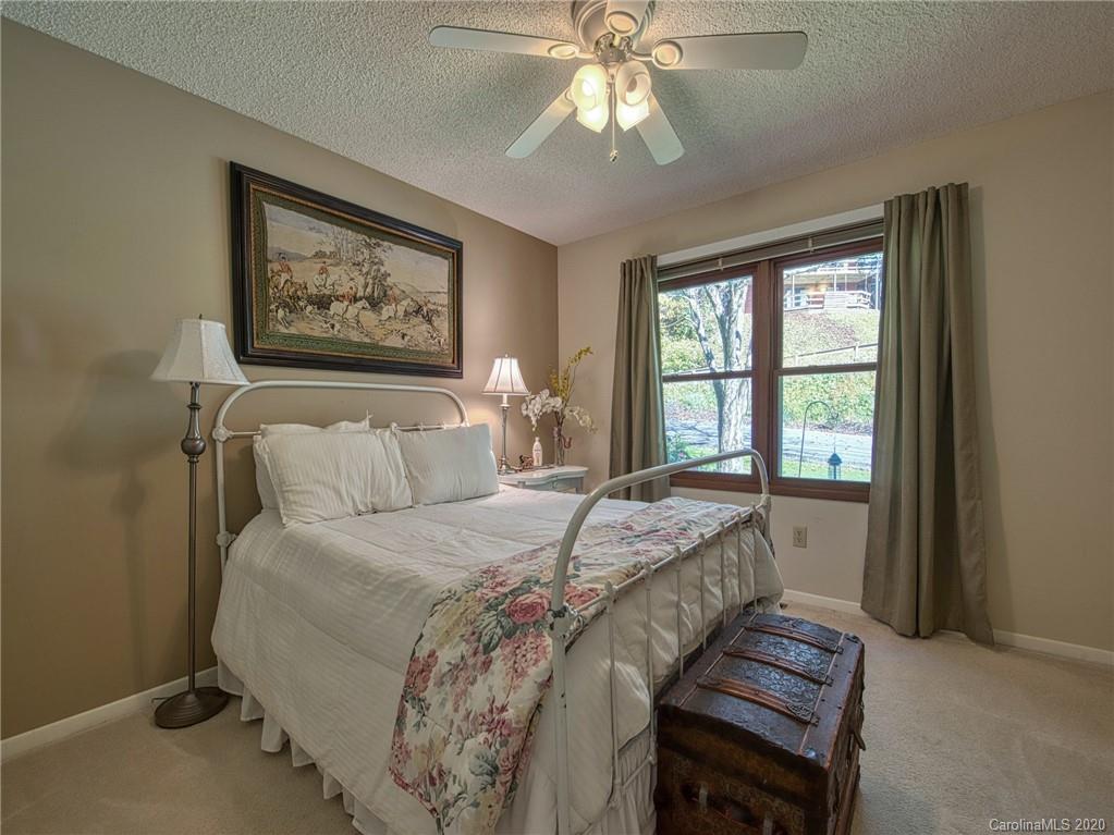 311 Riddle Cove Road Maggie Valley, NC 28751 - Photo 22 of 35 a bedroom with a bed and a large window