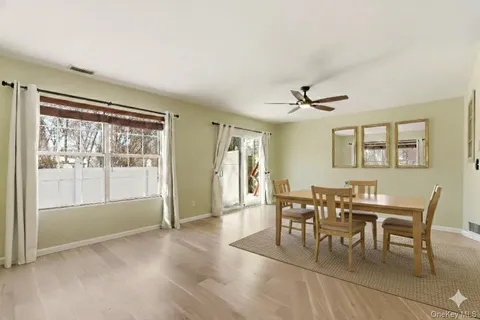 a view of a livingroom with wooden floor and a ceiling fan