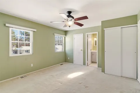 a bedroom with a bed and windows