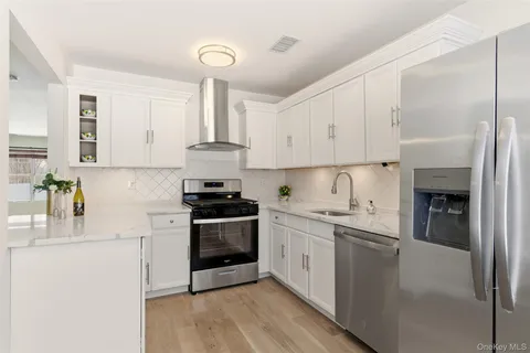 a kitchen with stainless steel appliances a sink stove and cabinets