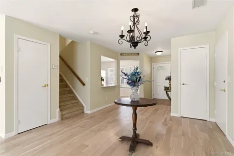 a view of a hallway with wooden floor and chandelier