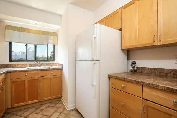 a kitchen with a refrigerator sink and cabinets