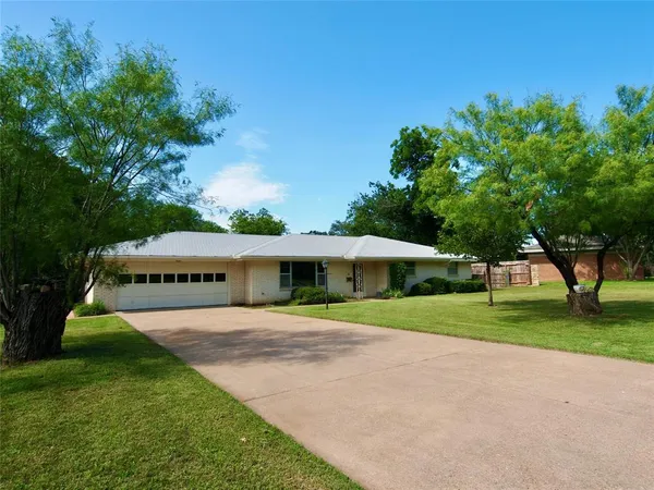 a view of an house with backyard and trees
