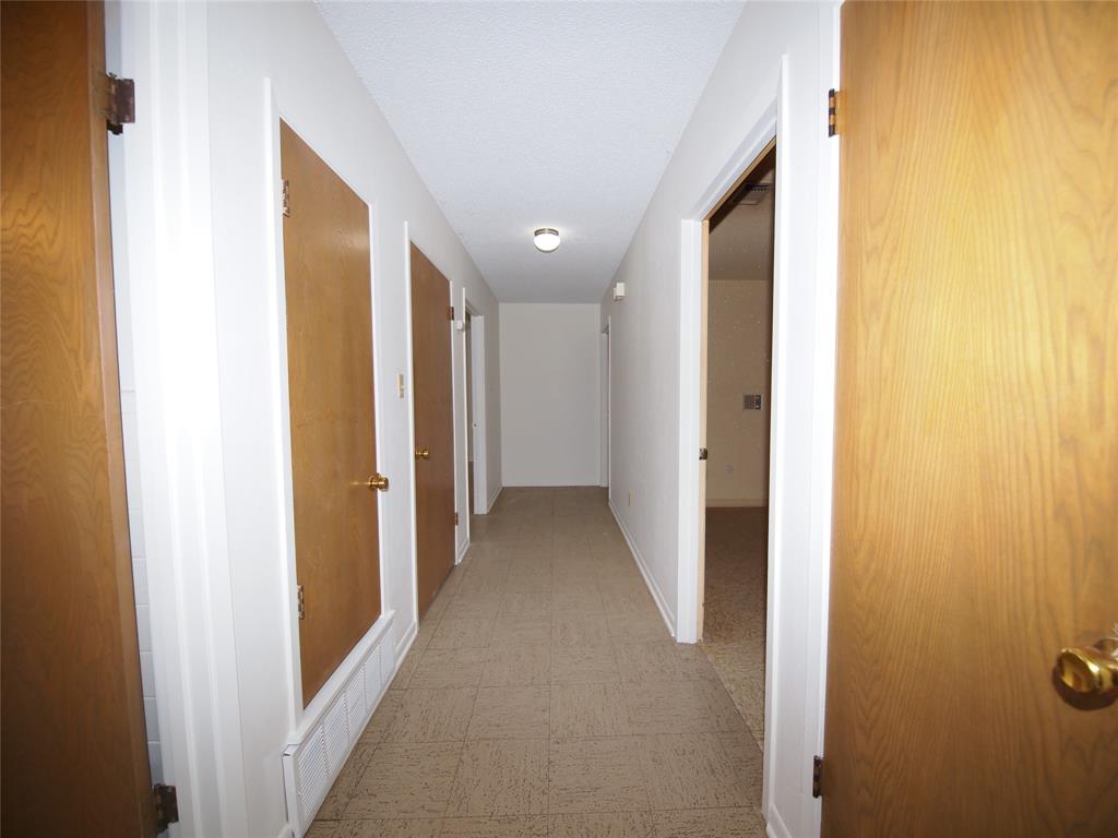 1441 Brazos Street Graham, TX 76450 - Photo 12 of 34 a view of a hallway with wooden floor