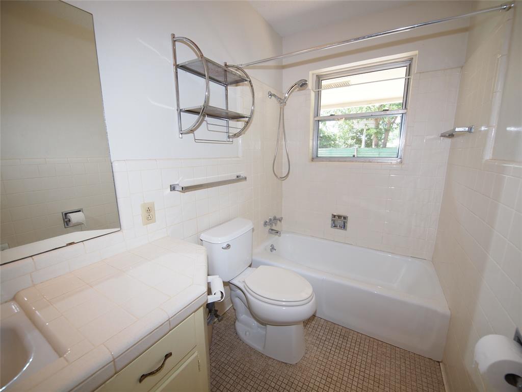 1441 Brazos Street Graham, TX 76450 - Photo 16 of 34 a bathroom with a toilet and a shower