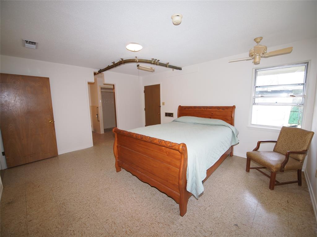 1441 Brazos Street Graham, TX 76450 - Photo 18 of 34 a bedroom with a bed and a chair