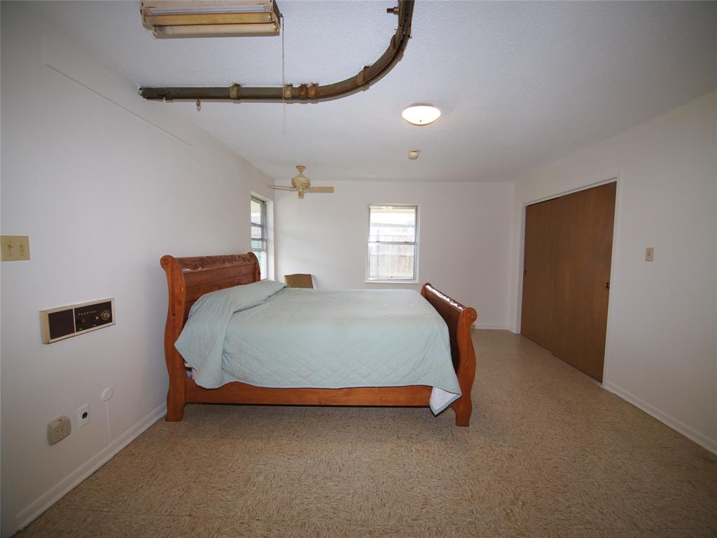 1441 Brazos Street Graham, TX 76450 - Photo 19 of 34 a bed room with a bed and a chandelier
