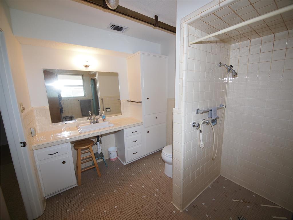 1441 Brazos Street Graham, TX 76450 - Photo 21 of 34 a bathroom with a double vanity sink mirror and shower