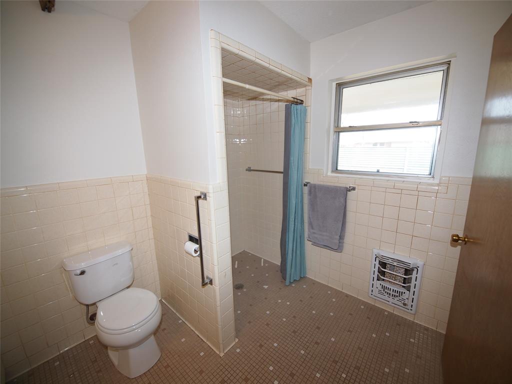 1441 Brazos Street Graham, TX 76450 - Photo 22 of 34 a bathroom with a toilet and a shower